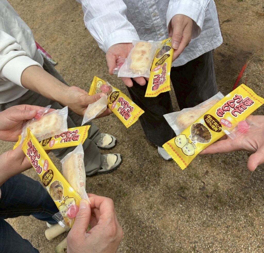 モルック練習の合間に、メンバーそれぞれが桜えびかきもちを手に持っている様子